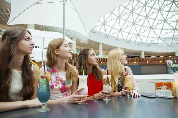 Cerca de cuatro mujeres jóvenes atractivas que beben cócteles en la tienda — Foto de Stock