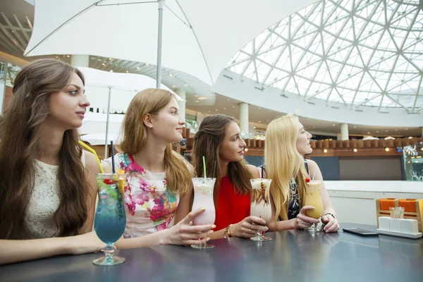 Закрыть четыре привлекательные молодые женщины, пьющие коктейли в магазине — стоковое фото