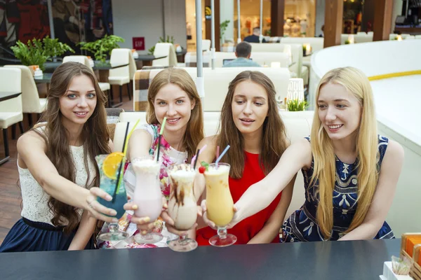 Stäng upp fyra attraktiva unga kvinnor dricker cocktails i shopp — Stockfoto