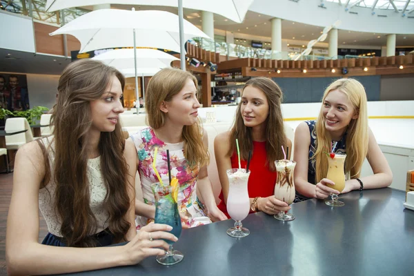 Gros plan sur quatre jolies jeunes femmes buvant des cocktails en boutique — Photo