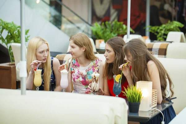 Gros plan sur quatre jolies jeunes femmes buvant des cocktails en boutique — Photo