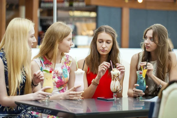 Chiudi quattro attraenti giovani donne che bevono cocktail nel negozio — Foto Stock