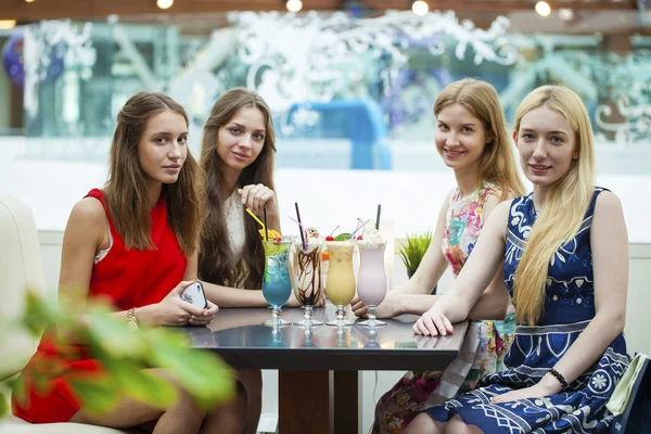 Cerca de cuatro mujeres jóvenes atractivas que beben cócteles en la tienda — Foto de Stock