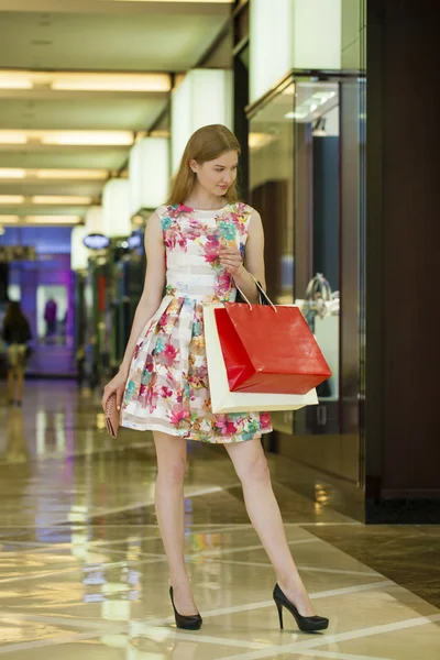 Jeune femme blonde avec des sacs à provisions dans le centre commercial — Photo