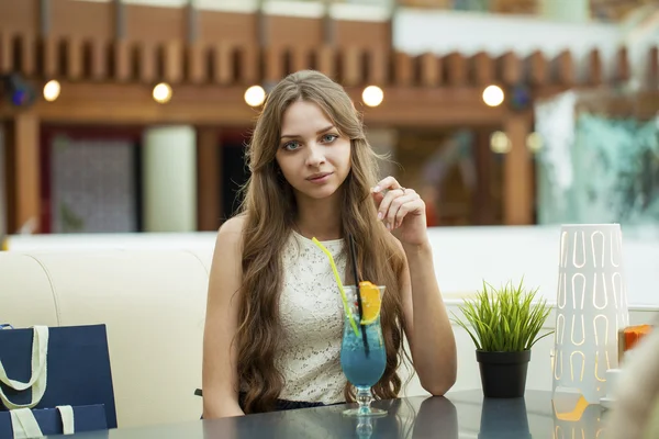 Jeune femme buvant un cocktail dans un café — Photo