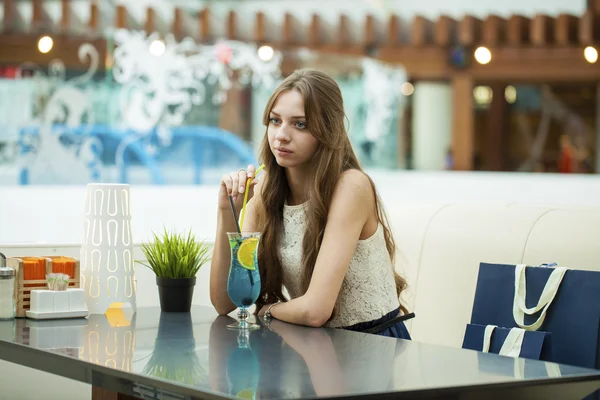 Jeune femme buvant un cocktail dans un café — Photo