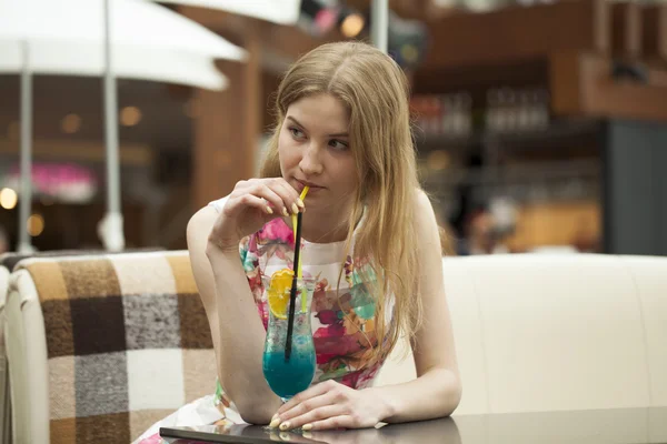 年轻女人喝鸡尾酒的一家咖啡馆 — 图库照片