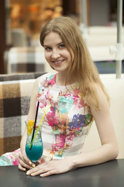 Jeune femme buvant un cocktail dans un café — Photo