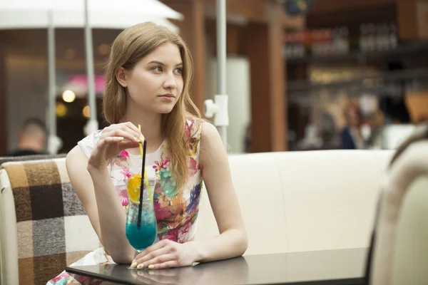 Jovem mulher bebendo coquetel em um café — Fotografia de Stock