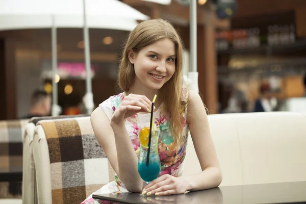 Jeune femme buvant un cocktail dans un café — Photo