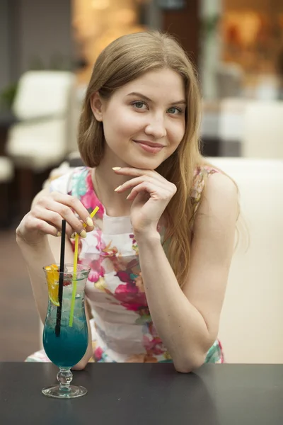 Young woman drinking cocktail in a cafe — Stock Photo, Image