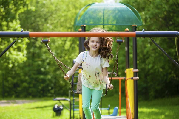 Little girl on a swing in the summer park — Stock Photo, Image