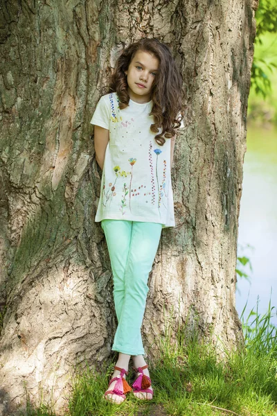 Kleines Mädchen auf Baumstamm — Stockfoto