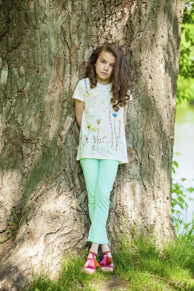 Kleines Mädchen auf Baumstamm — Stockfoto