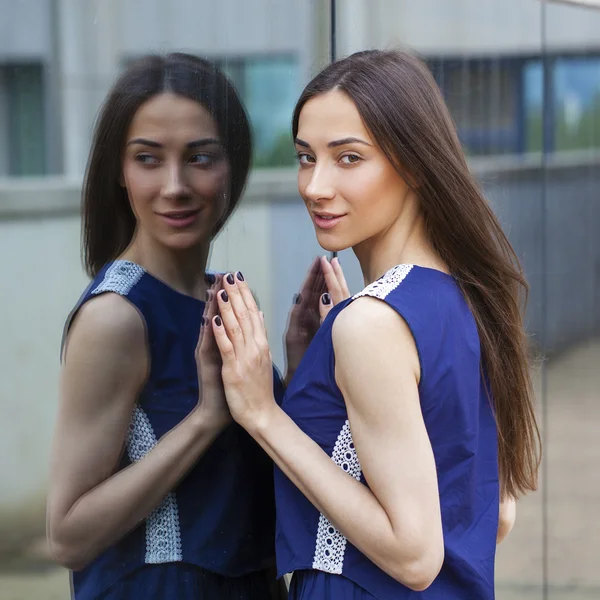 Elegante signora in abito blu posa vicino parete specchiata — Foto Stock