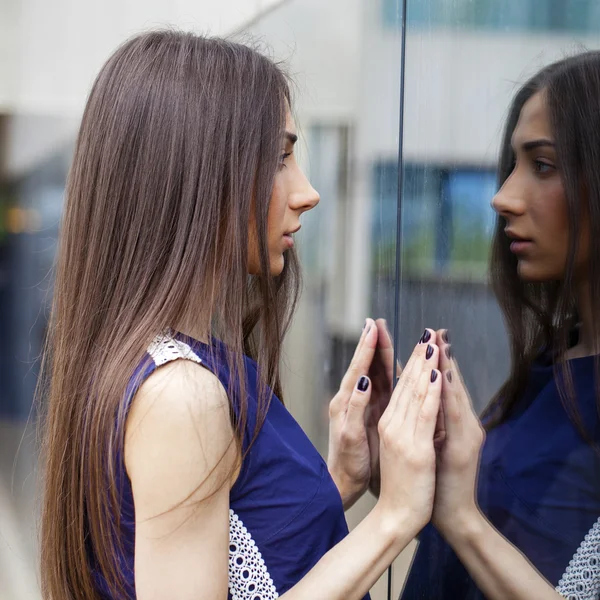 Stylische Dame im blauen Kleid posiert vor verspiegelter Wand — Stockfoto