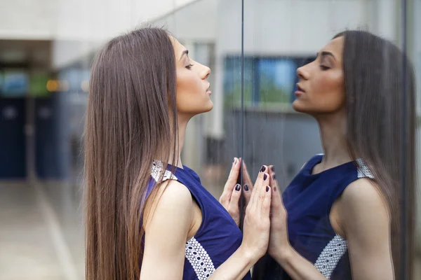 Senhora elegante em vestido azul posando perto de parede espelhada — Fotografia de Stock
