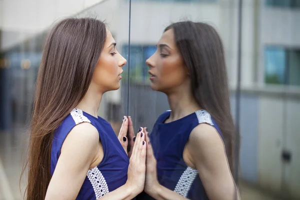 Senhora elegante em vestido azul posando perto de parede espelhada — Fotografia de Stock