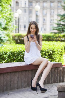 Genç esmer kadın telefonda mesaj okuma