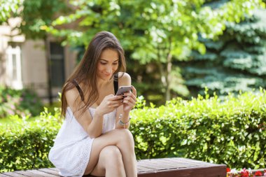 Genç esmer kadın telefonda mesaj okuma