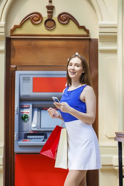 Счастливая брюнетка снимает деньги с кредитной карты в банкомате — стоковое фото