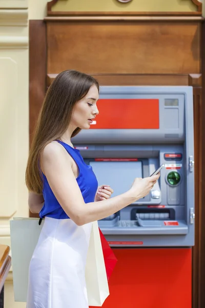 Happy brunette woman withdrawing money from credit card at ATM — Stock Photo, Image