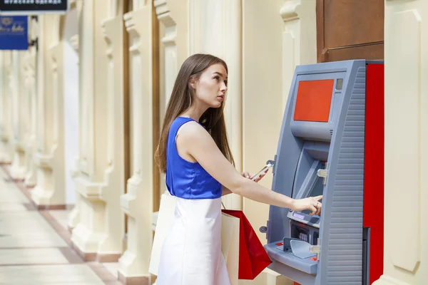 Щасливі брюнетка жінка знімати гроші з кредитної картки в банкоматі — стокове фото