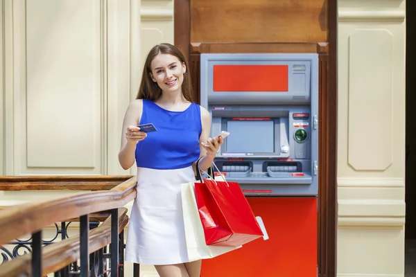 Femme brune heureuse retirant de l'argent de la carte de crédit au distributeur automatique — Photo