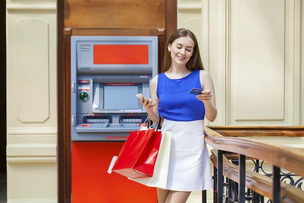 Femme brune heureuse retirant de l'argent de la carte de crédit au distributeur automatique — Photo