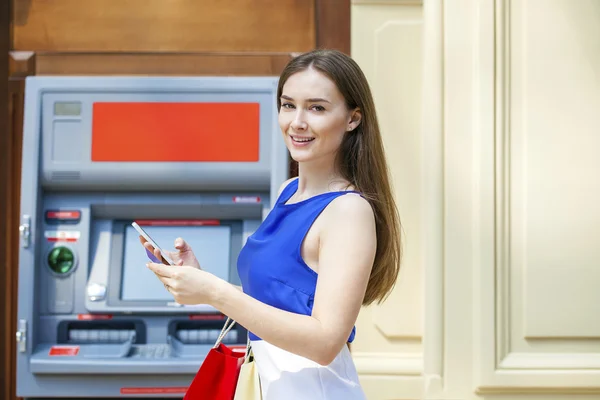 Mujer morena feliz retirando dinero de la tarjeta de crédito en el cajero automático — Foto de Stock