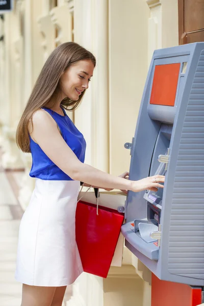 Щасливі брюнетка жінка знімати гроші з кредитної картки в банкоматі — стокове фото