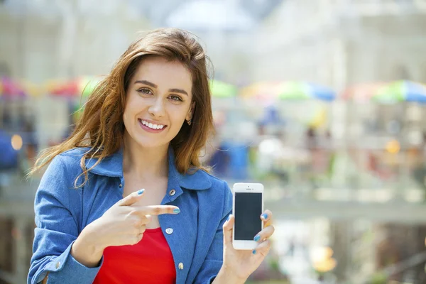 Joven hermosa chica mostrando la pantalla de su teléfono inteligente — Foto de Stock