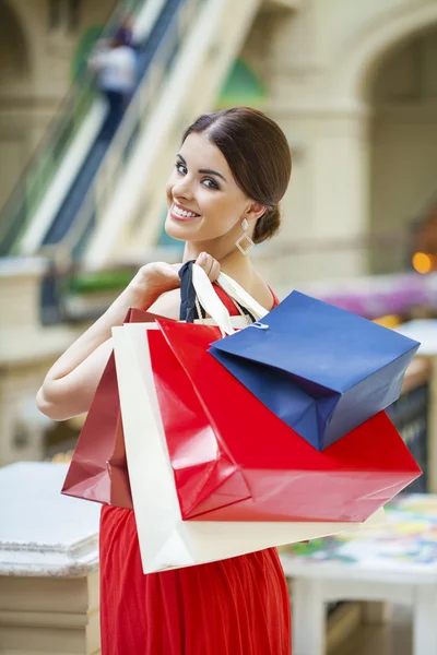 Mujer morena feliz con una bolsa roja —  Fotos de Stock