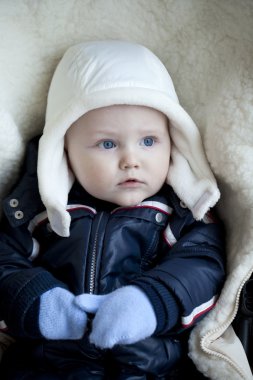 Bebek çocuk arabasındaki bebek kış giysileri içinde yalan söylüyor