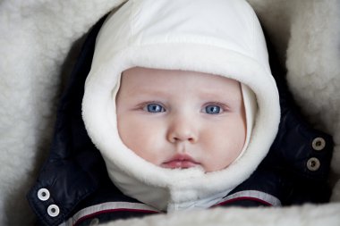 Bebek çocuk arabasındaki bebek kış giysileri içinde yalan söylüyor