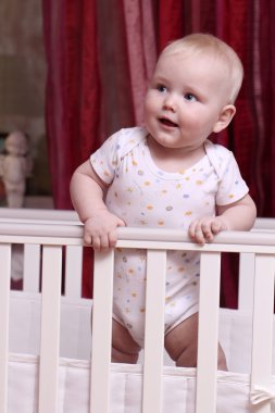 Küçük çocuk bir beşik içinde oturan