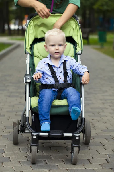 Mały chłopiec siedzi w wózek — Zdjęcie stockowe