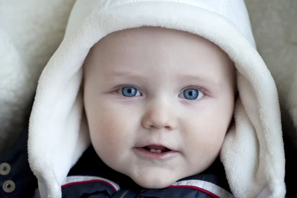 Menino infantil está deitado em um carrinho de bebê em roupas de inverno — Fotografia de Stock