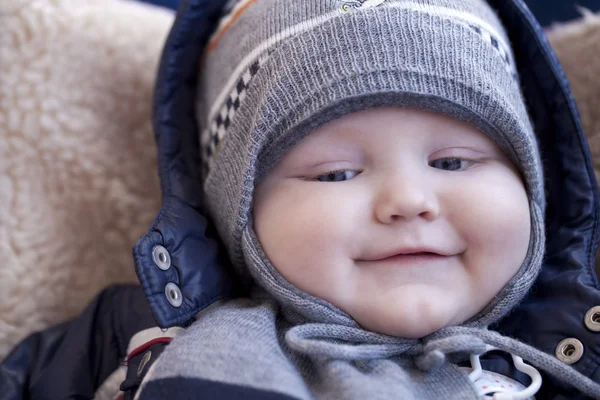 Niño está acostado en un cochecito con ropa de invierno —  Fotos de Stock