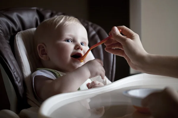 Menino sentado a uma mesa para se alimentar — Fotografia de Stock