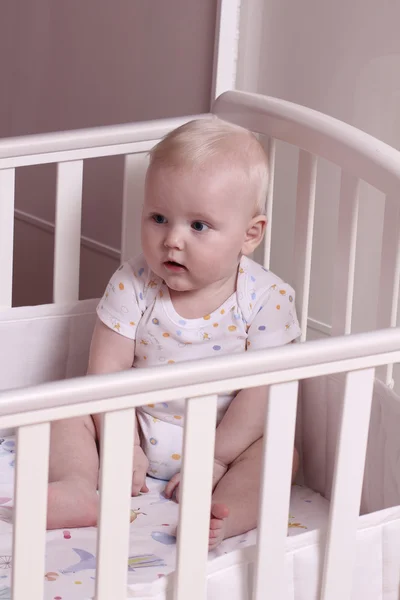 Little boy sitting in a crib — Stock Photo, Image