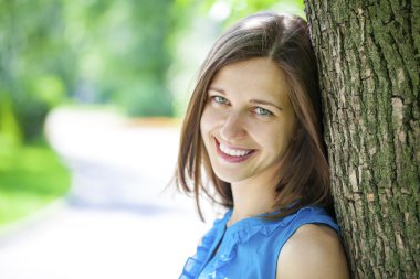 Gülümseyen genç bir kadının yakın plan portresi.