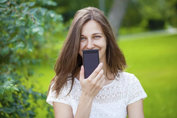 Krásná mladá dívka ukazuje váš smartphone obrazovky — Stock fotografie