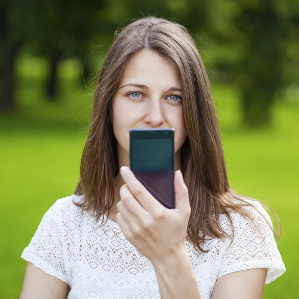 Krásná mladá dívka ukazuje váš smartphone obrazovky — Stock fotografie