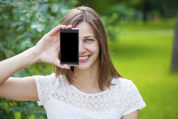 Jeune belle fille montrant l'écran de votre smartphone — Photo