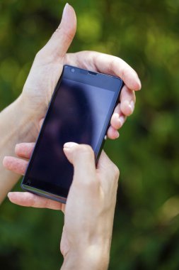 Modern bir kaygan smartphone tutan bir kadın eli yan görünüm 
