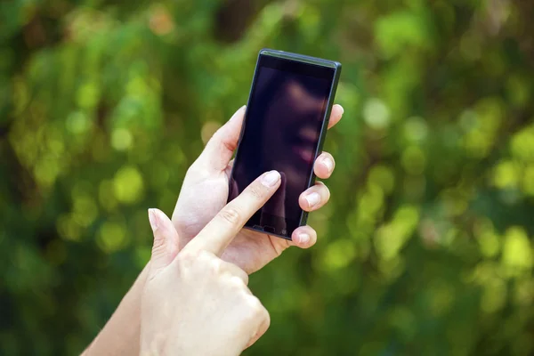 Sidovy av en kvinnas hand hållande en modern Smart smartphone — Stockfoto