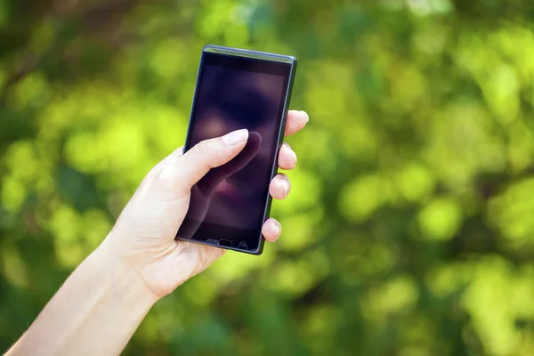 Vista lateral de la mano de una mujer sosteniendo un teléfono inteligente moderno —  Fotos de Stock