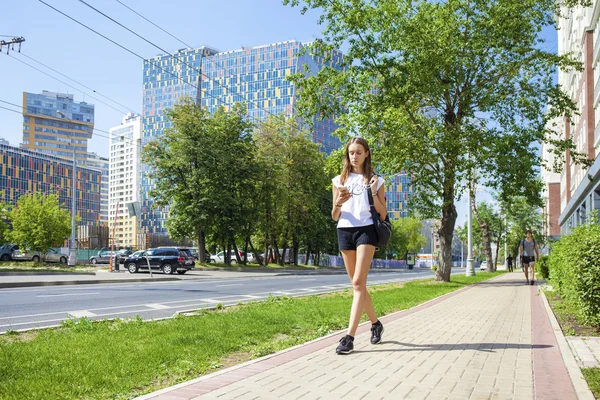 年轻漂亮的女人，在黑色的短的步行，在夏天大街上 — 图库照片