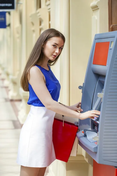 Счастливая брюнетка снимает деньги с кредитной карты в банкомате — стоковое фото
